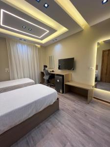 ein Schlafzimmer mit einem Bett und einem Schreibtisch mit Fernseher in der Unterkunft Aman Villa in New cairo