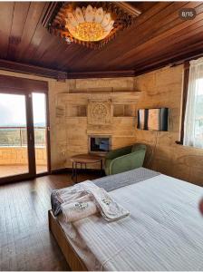 a bedroom with a bed and a chandelier at Helios Kaz Dağları in Edremit