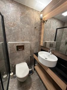 a bathroom with a white toilet and a sink at Helios Kaz Dağları in Edremit +16 photos