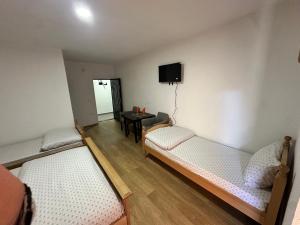 a room with two beds and a table with a tv at Hotel River in Gusinje