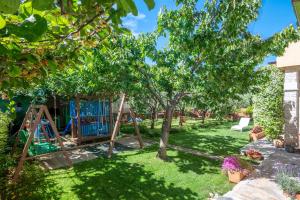 a garden with a swing set under a tree at Apartments Mirella in Novigrad Istria +32 photos