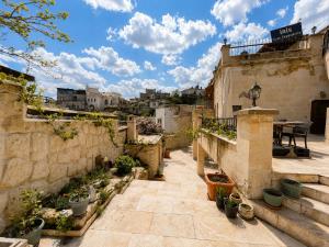 a courtyard with potted plants and a stone wall at Iris Cave Cappadocia in Ortahisar