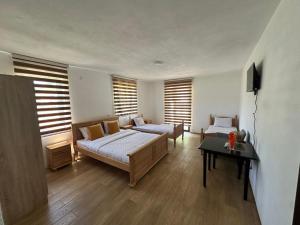 a bedroom with a bed and a couch and a table at Hotel River in Gusinje