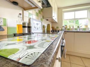 a kitchen with a counter with a glass counter top at Lily Pad 2 - Uk43901 in Nassington