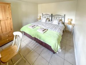 a bedroom with a large bed and a chair at Lily Pad 2 - Uk43901 in Nassington