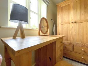 a table with a mirror and a lamp on it at Lily Pad 2 - Uk43901 in Nassington