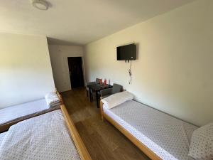 a room with two beds and a table with a tv at Hotel River in Gusinje