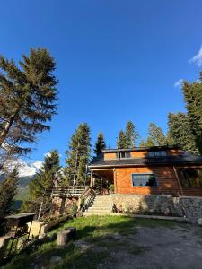 a log cabin in the woods with the mountains in the background at In The Forest in Mestia