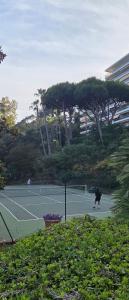a person playing tennis on a tennis court at CANNES La Mirandole in Golfe-Juan