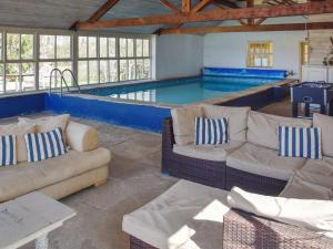 a swimming pool with couches and a couch in a house at Lily Pad 5 - Uk43913 in Nassington