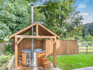 a gazebo with a hot tub in a yard at Shepherds Barn in Bollington