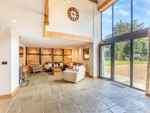 an open living room with a clock on the wall at Shepherds Barn in Bollington