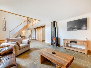 a living room with a couch and a wood stove at Shepherds Barn in Bollington
