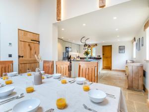 a dining room with a table and a kitchen at Shepherds Barn in Bollington