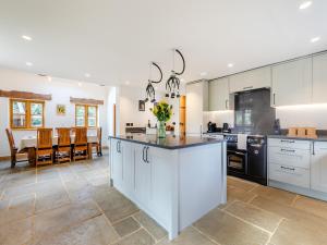 a large kitchen with white cabinets and a kitchen island at Shepherds Barn in Bollington +17 photos