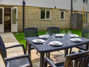 a black table and chairs with glasses and plates at Lily Pad 6 - Uk43915 in Nassington +19 photos