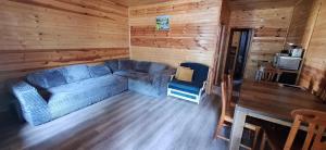 a living room with a blue couch in a log cabin at Вила ВлаиДа in Sapareva Banya
