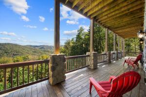 a deck with red chairs and a view of the mountains at Cranberry View Lodge in Newland