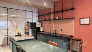 a man standing in a kitchen with a refrigerator at Joi Boutique Bãi Trước in Vung Tau +11 photos