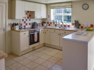 a kitchen with white cabinets and a stove top oven at Lily Pad 1 - Uk49648 in Nassington