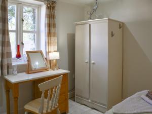 a bedroom with a desk with a mirror and a cabinet at Lily Pad 1 - Uk49648 in Nassington