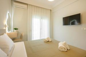 a bedroom with two towels on a bed with a television at Elia Apartments in Ierissos