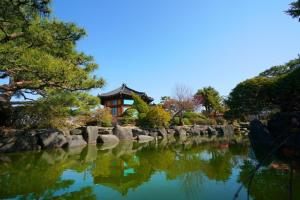a garden with a pond in front of a building at Boseong Carmel Royal Pension in Boseong +6 photos