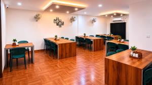 a room with tables and chairs in a room at Stanza Premium Hotels in Bhubaneshwar