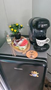 a coffee maker and a cup on top of a refrigerator at Purple Diamond in Damiş