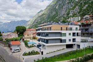a building in front of a mountain at Boka Bay by MN Property in Dobrota