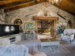 a living room with a tv and a stone wall at Tennox Parlour - Ukc3542 in Kilbirnie