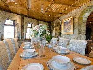 a long wooden table with plates and glasses on it at Tennox Parlour - Ukc3542 in Kilbirnie