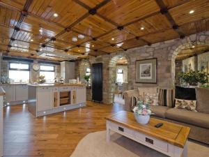 a large living room with a stone wall at Tennox Parlour - Ukc3542 in Kilbirnie +24 photos