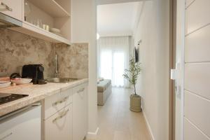 a kitchen with white cabinets and a sink at Elia Apartments in Ierissos +48 photos