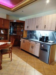 a kitchen with wooden cabinets and a table and a counter top at Marilyn's house in Amarynthos