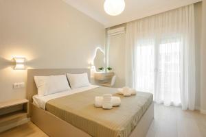 a bedroom with a bed with two towels on it at Elia Apartments in Ierissos
