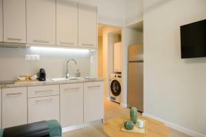 a kitchen with white cabinets and a wooden table at Elia Apartments in Ierissos
