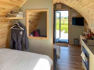 a bedroom with a bed and a mirror in a cabin at The Rounton - Ukc9284 in Brompton
