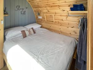 a bed in a room with a wooden wall at The Rounton - Ukc9284 in Brompton