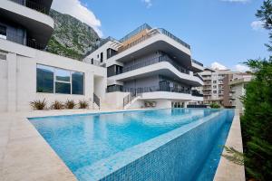 an image of a swimming pool in front of a building at Boka Bay by MN Property in Dobrota
