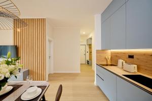 a kitchen with white cabinets and a table with a vase of flowers at Boka Bay by MN Property in Dobrota