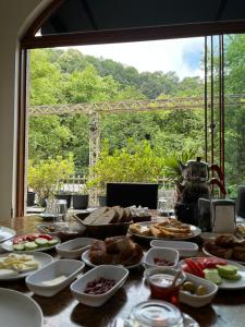 a table with plates of food on top of it at Mersu Ala Konak Otel maşukiye sapanca in Kocaeli