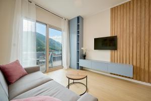 a living room with a couch and a tv at Boka Bay by MN Property in Dobrota