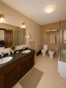 a bathroom with two sinks and a toilet and a shower at Hotel Arresi in Arminza