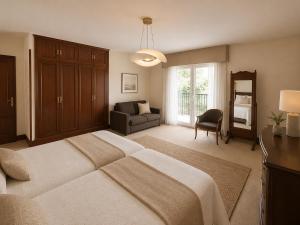 a bedroom with a bed and a couch and a chair at Hotel Arresi in Arminza