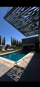 a view of a swimming pool with awning over it at Mandarine de medeline in Ouled el guerne