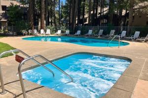 a large swimming pool with blue water and chairs at St. Moritz 13 in Mammoth Lakes