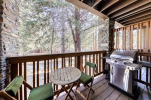 a screened in porch with a grill and chairs at The Summit 5 in Mammoth Lakes