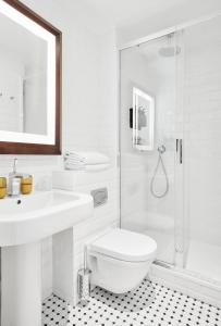 a bathroom with a toilet and a sink and a shower at Plaza Tour Eiffel in Paris +39 photos
