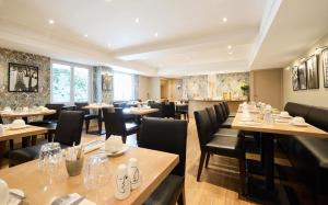 a restaurant with wooden tables and black chairs at Plaza Tour Eiffel in Paris